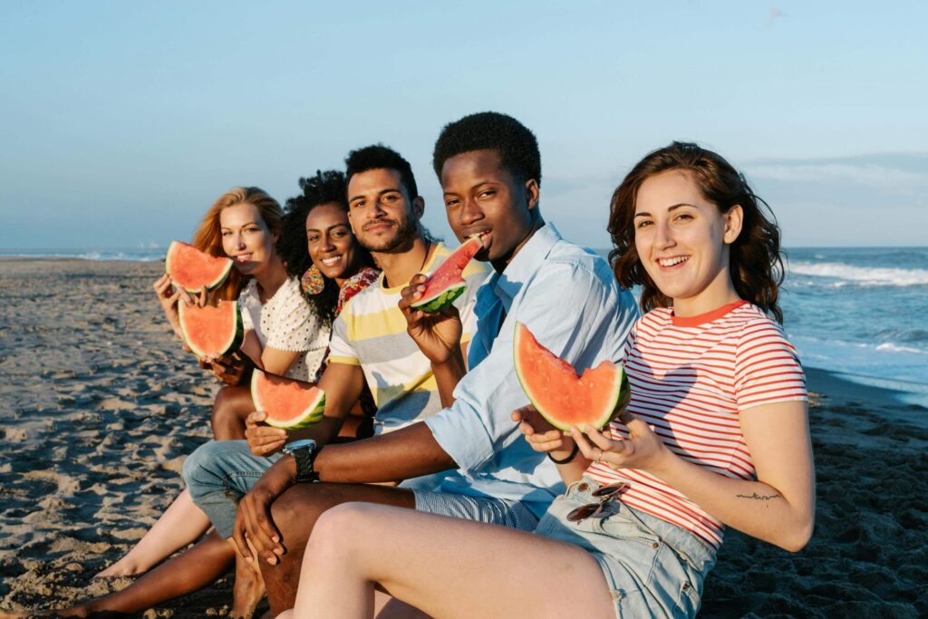 company values and eco-friendly people eating watermelon sitting on the beach